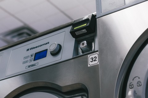 Close-up of a Wascomat commercial washer control panel and card reader at Fresh Fold