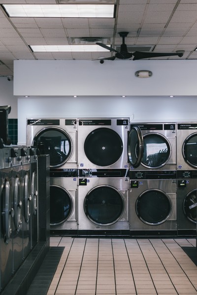 Wide view of Dexter stack dryers and washers filling the Fresh Fold laundromat floor