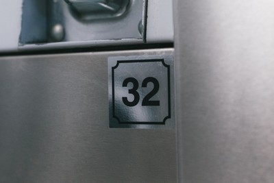 Machine number 32 label on a stainless steel washer at Fresh Fold