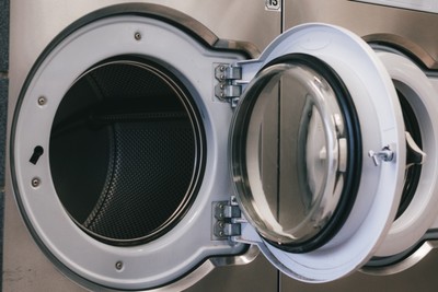 Open door on a commercial front-loading washer ready for a new load at Fresh Fold