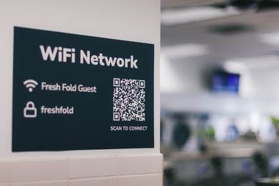Fresh Fold guest WiFi sign with QR code on the laundromat wall
